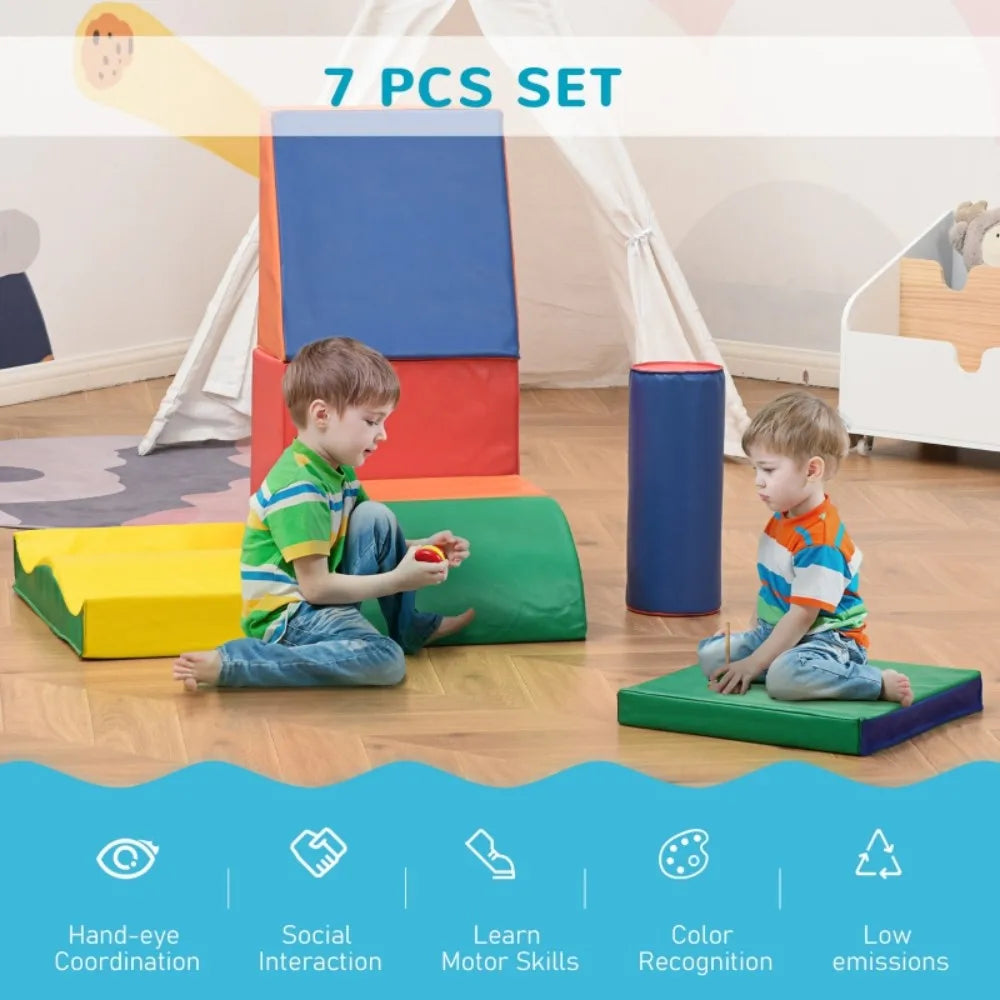 Two children playing with colorful soft play equipment in a room.