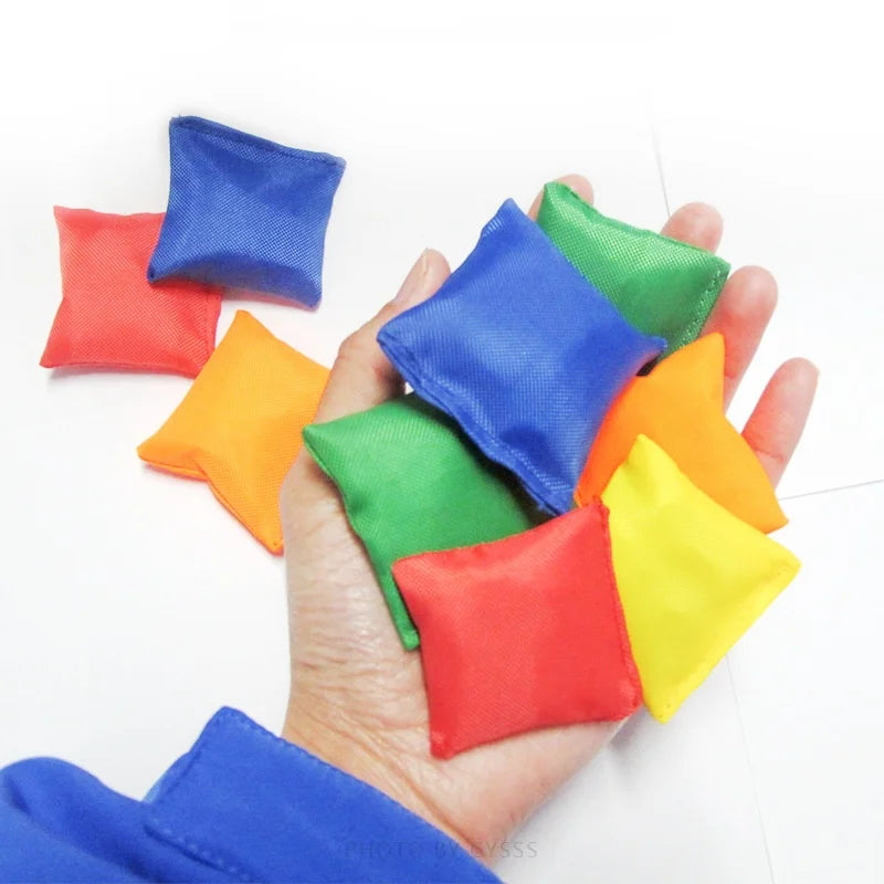 Hand holding colorful bean bags against a white background