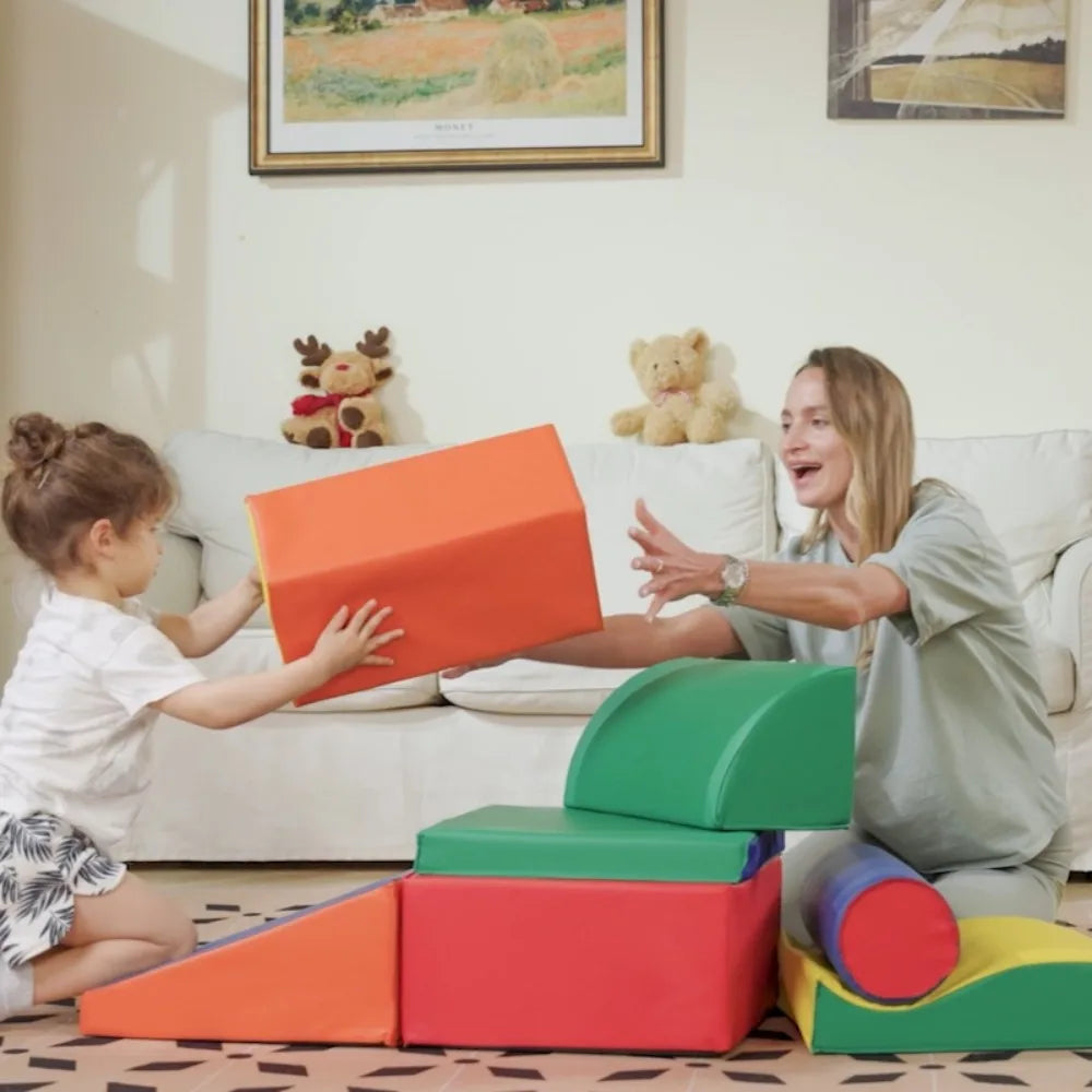 Woman and child playing with colorful foam play mats in a living room.